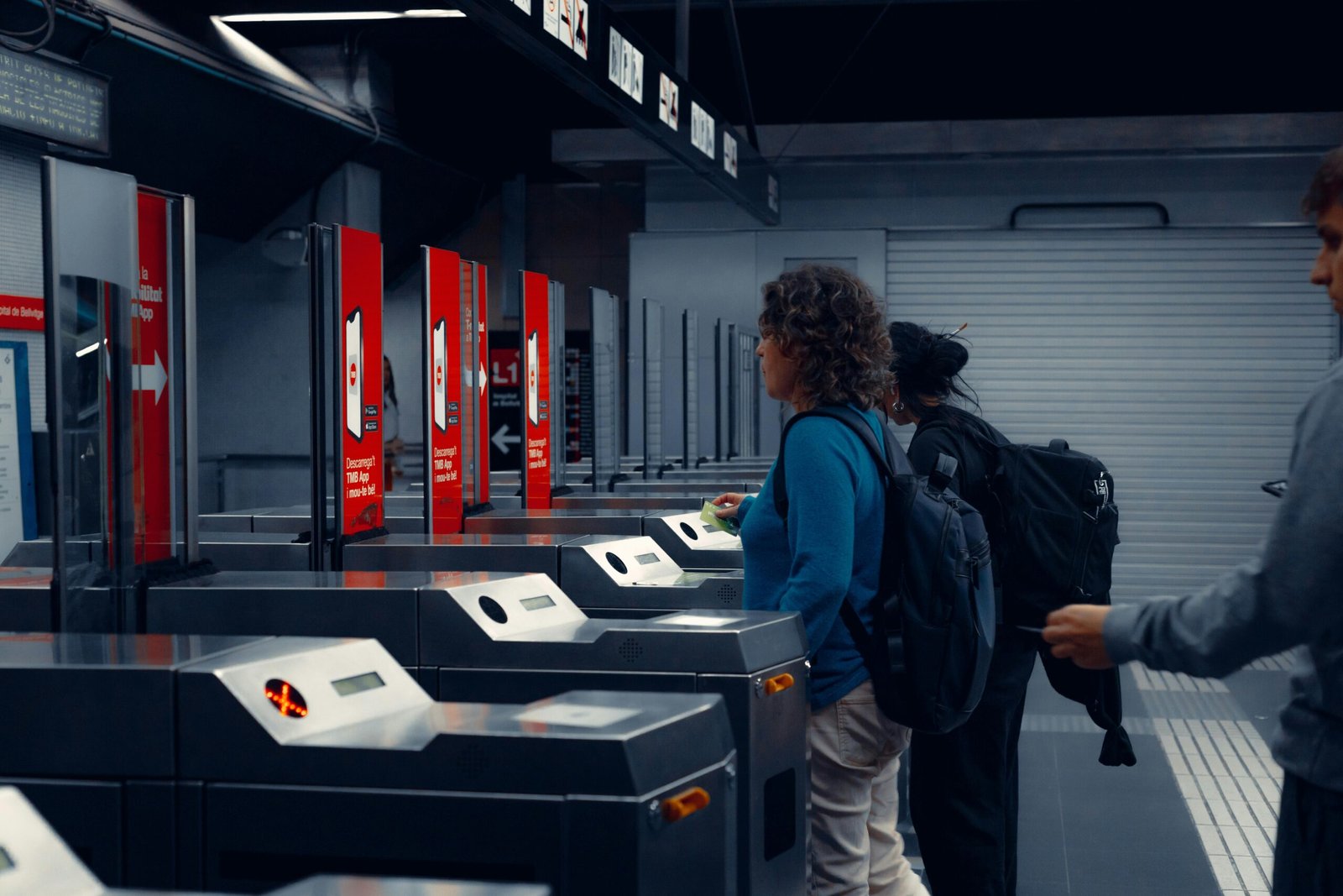 Urban commuters using turnstiles at a modern subway station, showcasing daily public transportation routine.